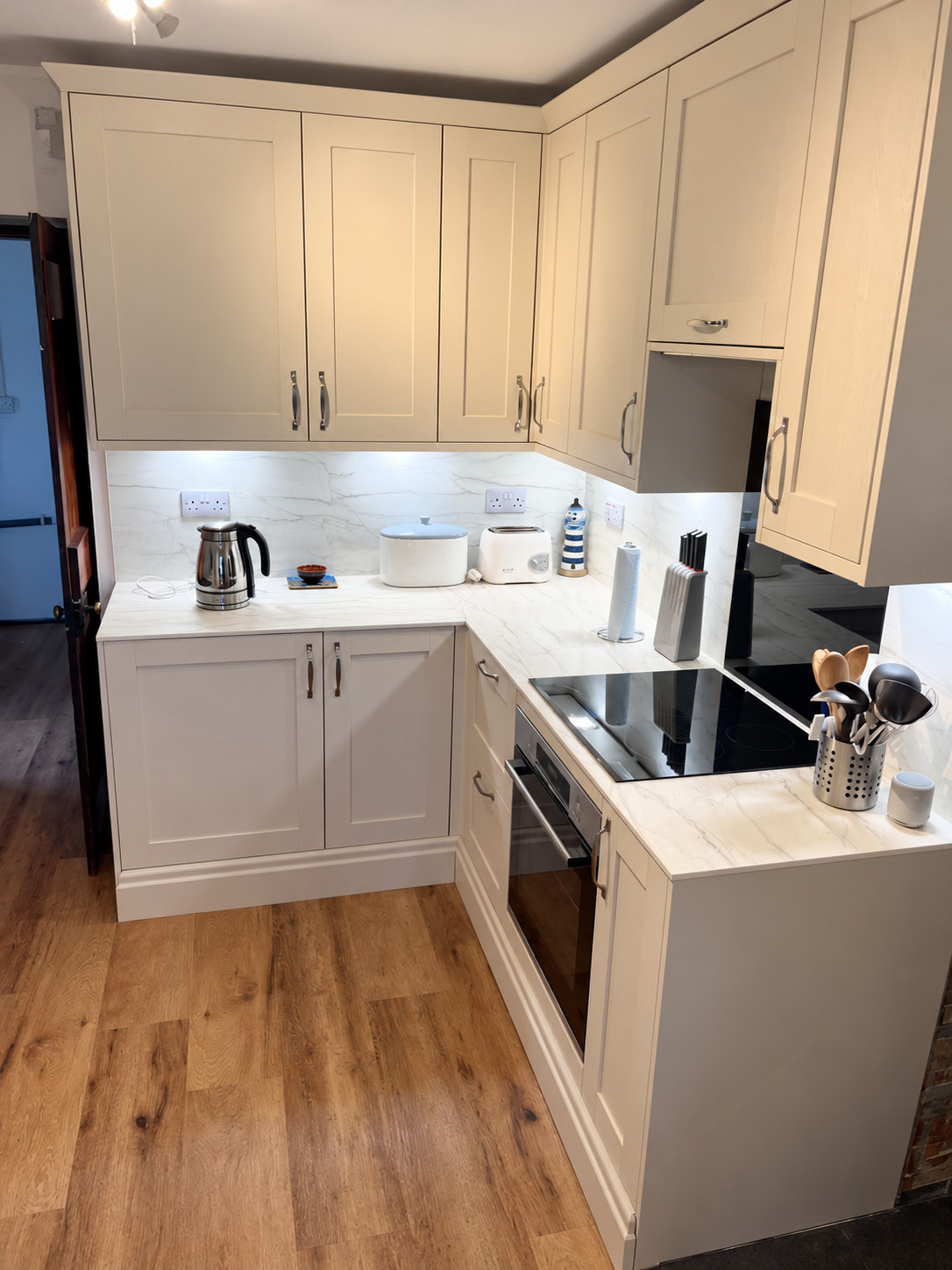 Fitted Howdens kitchen in Lamlash with pale cabinets and marble-effect worktops